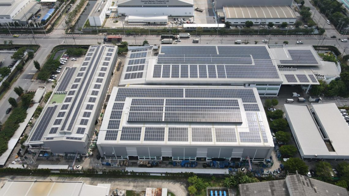 Rooftop solar panels are installed at an industrial site to take advantage of the larger surface areas